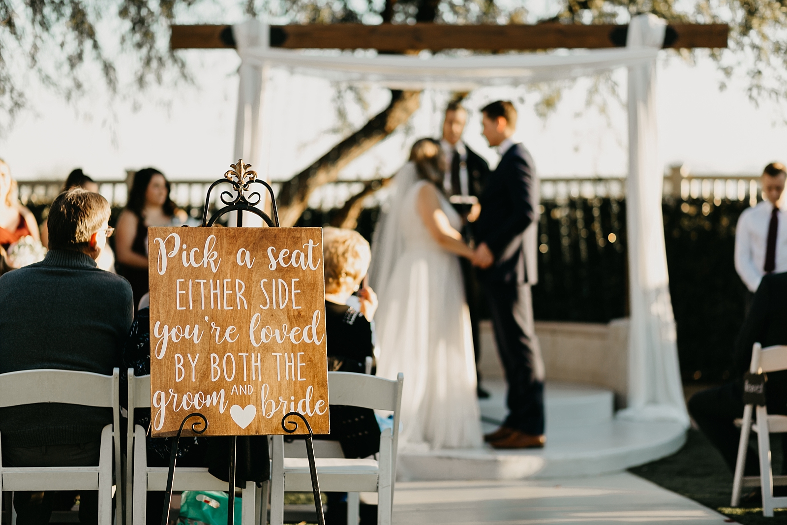 Ceremony Palm Valley by Wedgewood Wedding - pick a seat either side you're loved by both the groom and bride sign