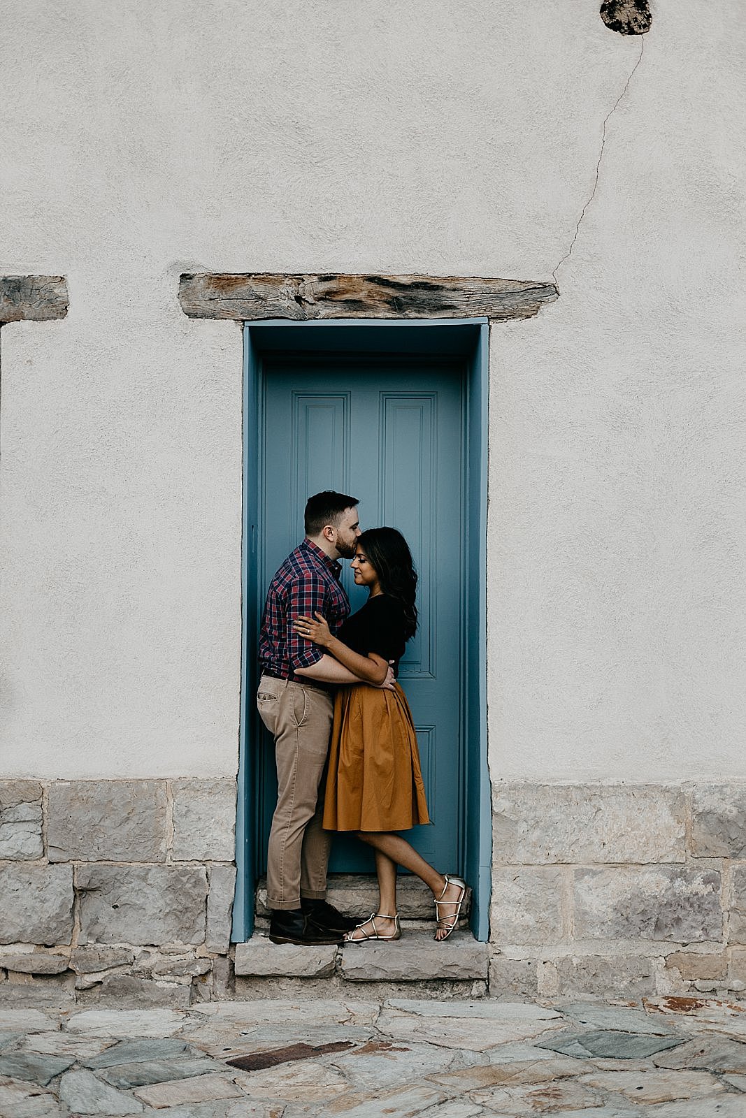 couple in colorful adobe doorway in tucson engagement photos samantha patri photography