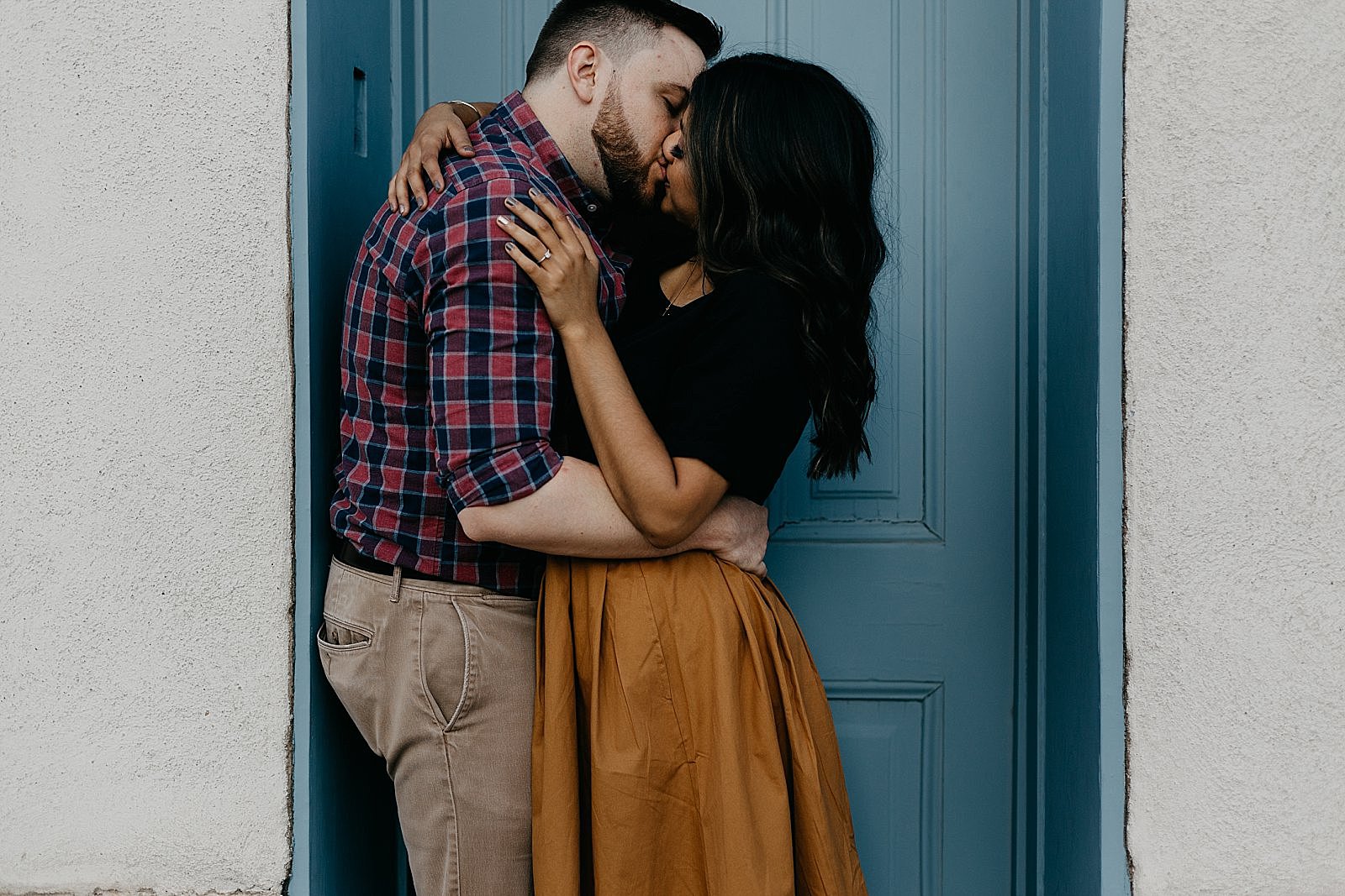 couple kissing in colorful adobe doorway in tucson