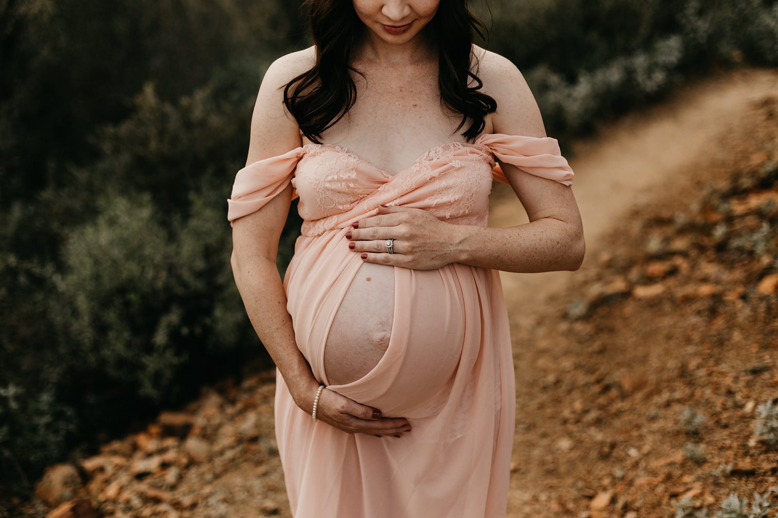 Pregnant belly with pink dress split down the middle