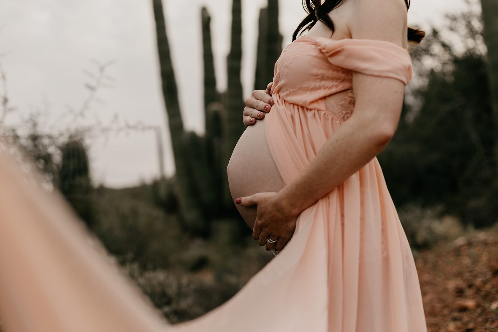 Unique desert maternity photos with dramatic pink dress
