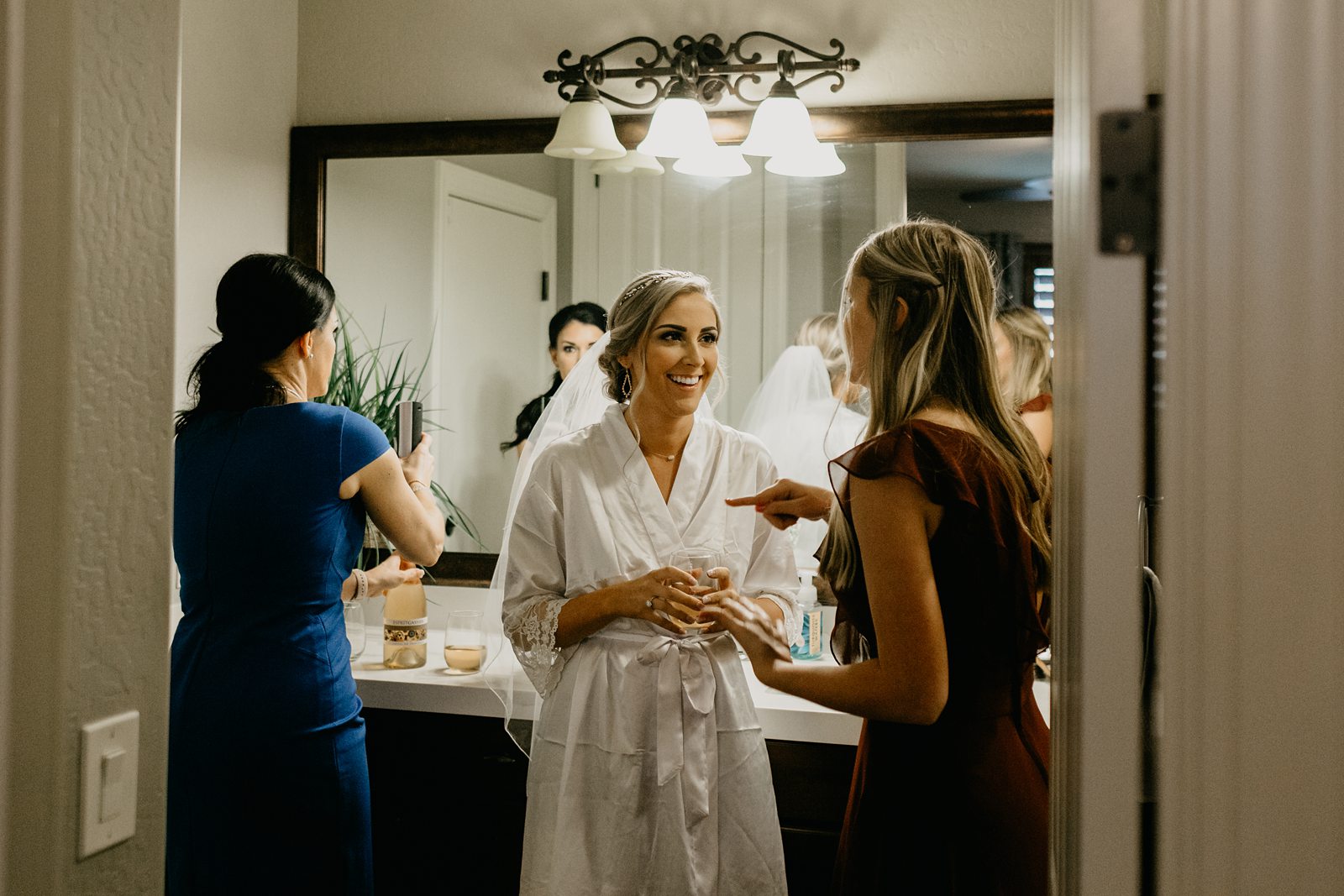 bride smiling getting ready and her parents bathroom for her backyard elopement in Glendale Arizona