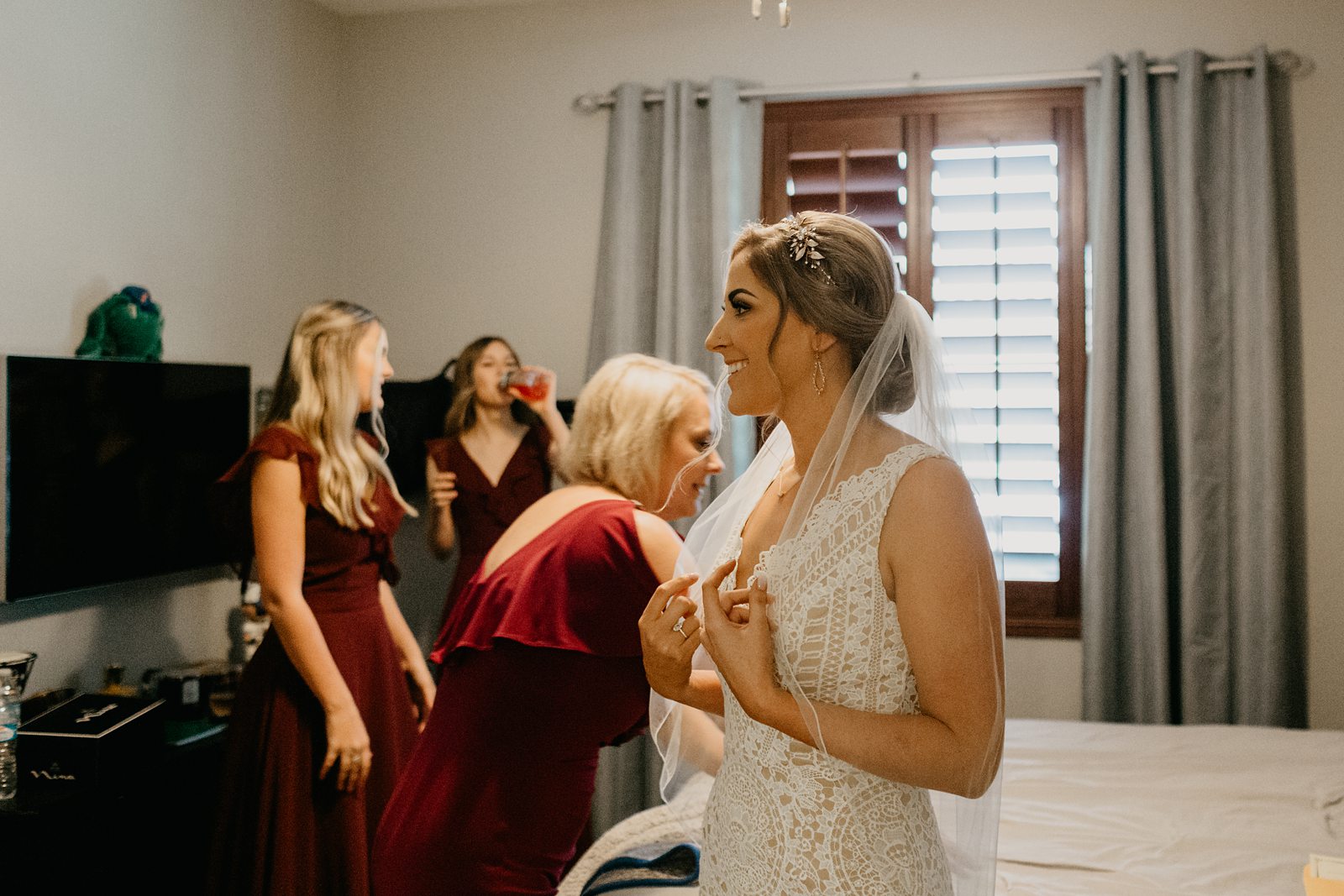 pride laughing getting ready in her parents' bedroom for her backyard elopement in Glendale Arizona