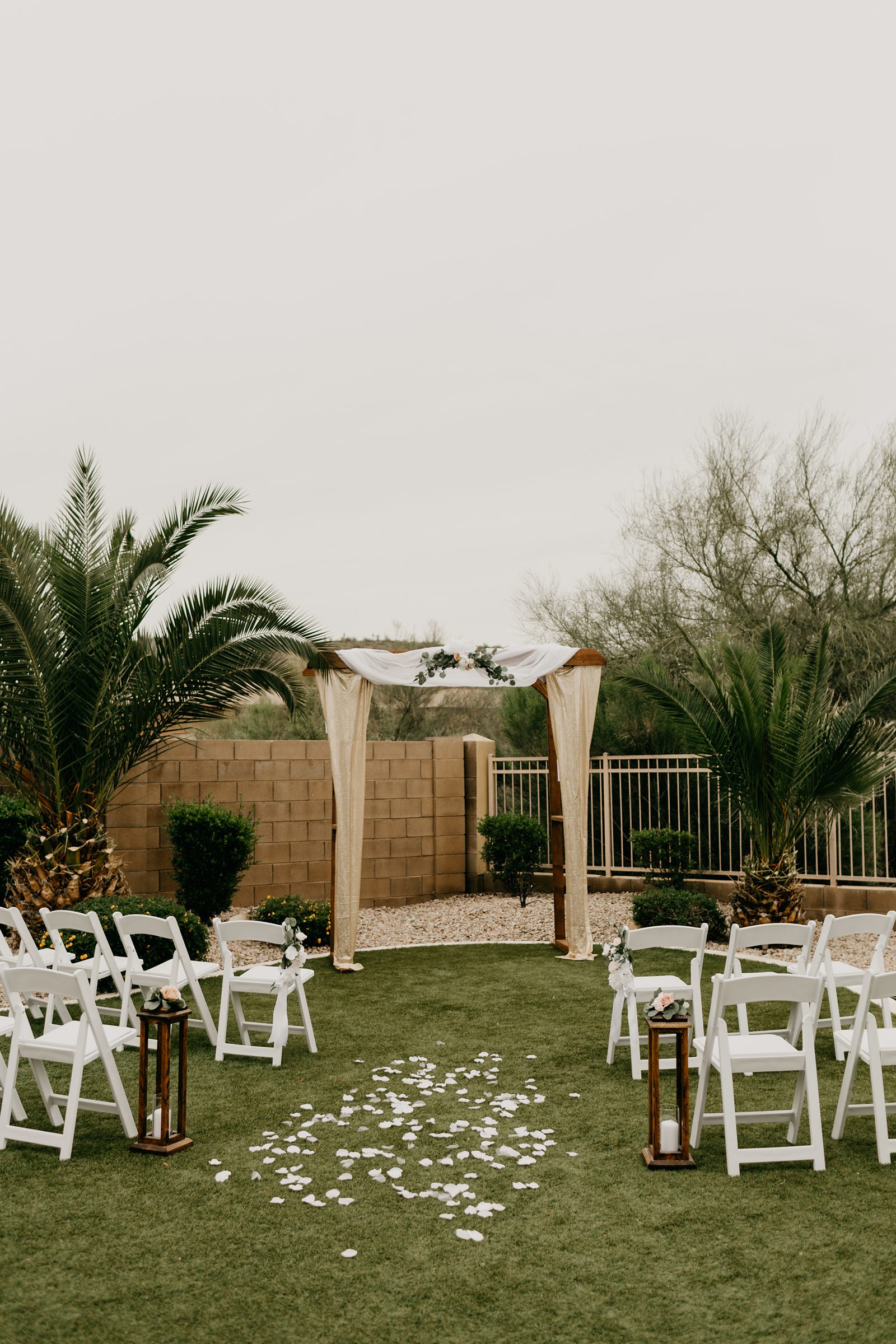 Ceremony setup with chairs and decorated arch for backyard elopement in Glendale AZ