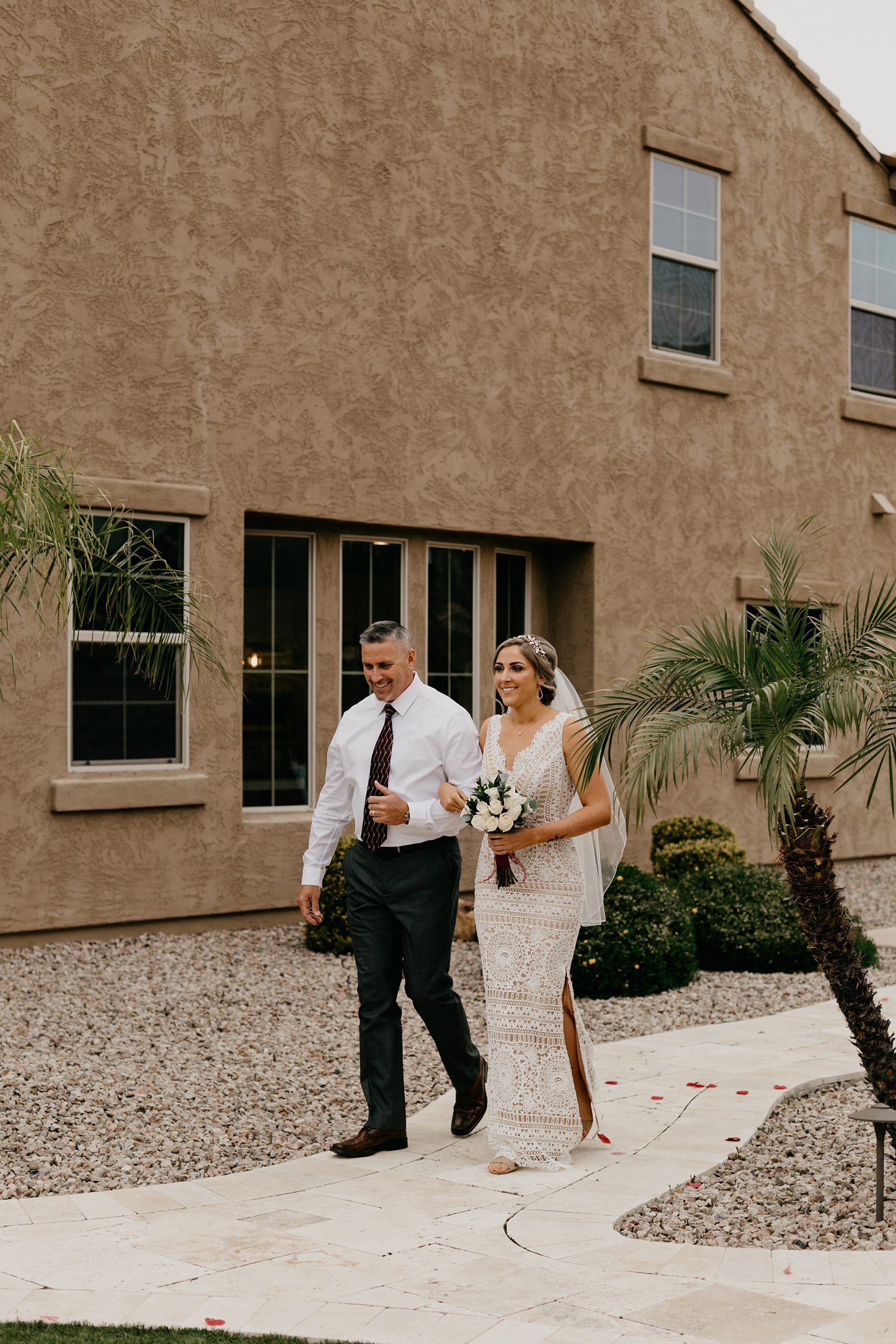 A bride walking down the aisle with her father for her intimate backyard wedding in Phoenix Arizona