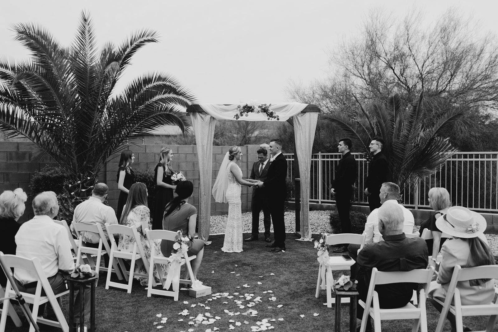 A bride and groom up at the altar for their ceremony during their backyard elopement in Glendale Az black and white photo