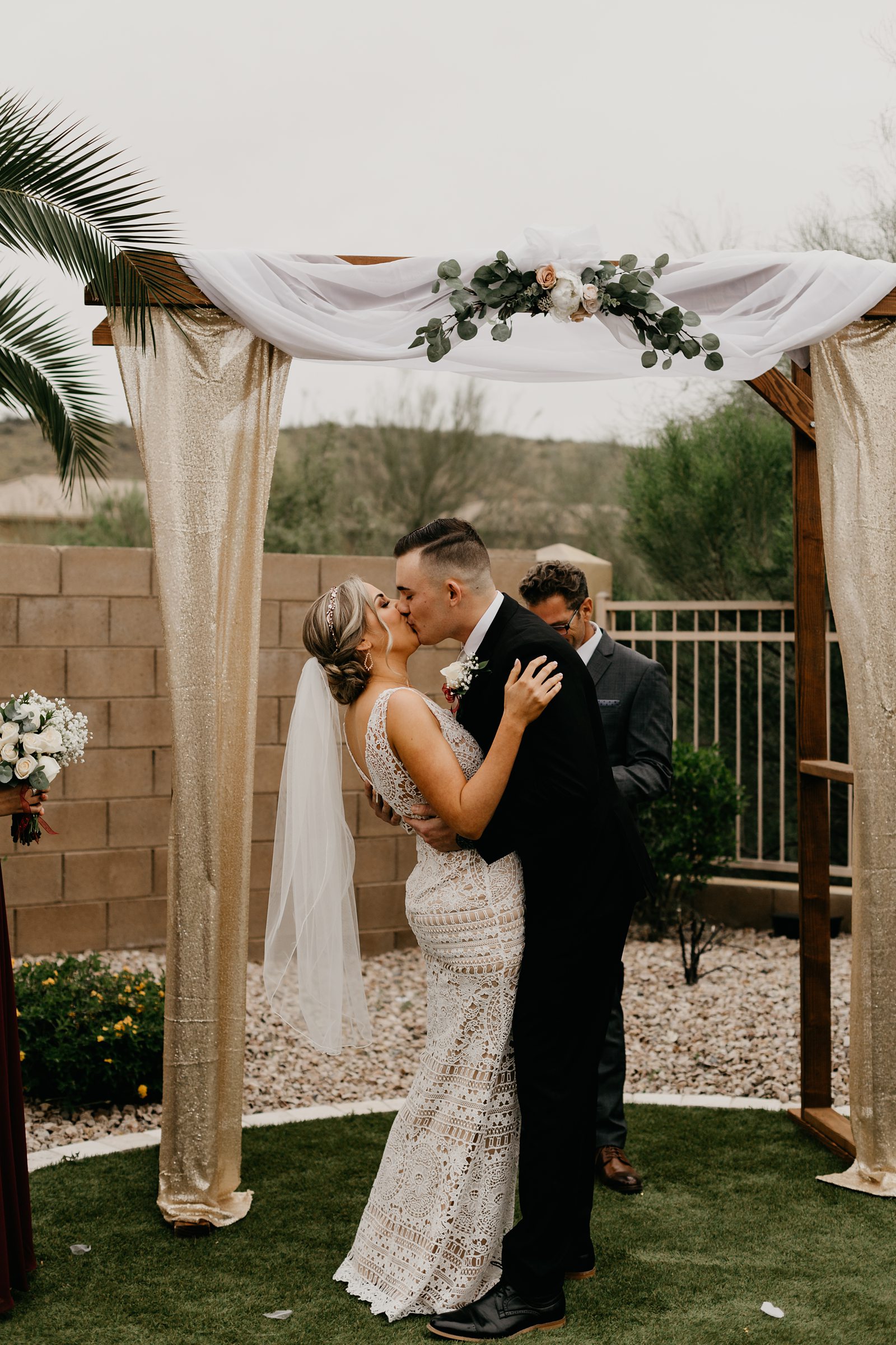 a brided and groom's first kiss during the ceremony for their intimate backyard wedding photos in Arizona