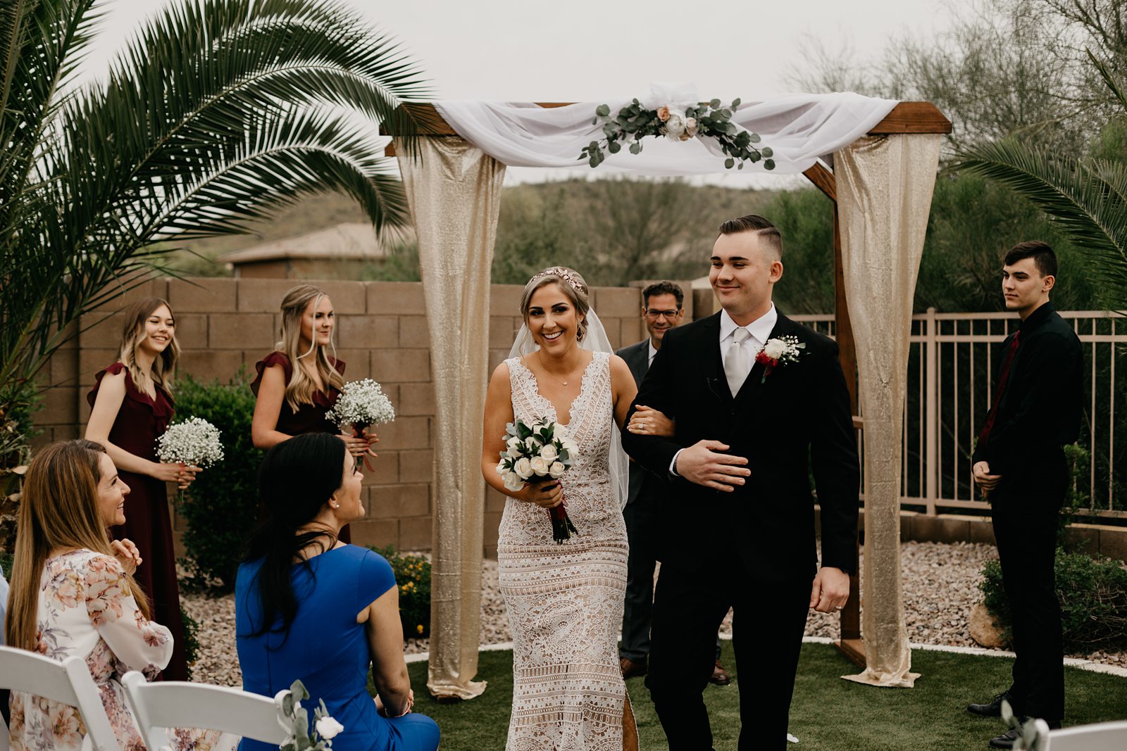 A bride and groom walking down the aisle at their intimate backyard wedding in Arizona