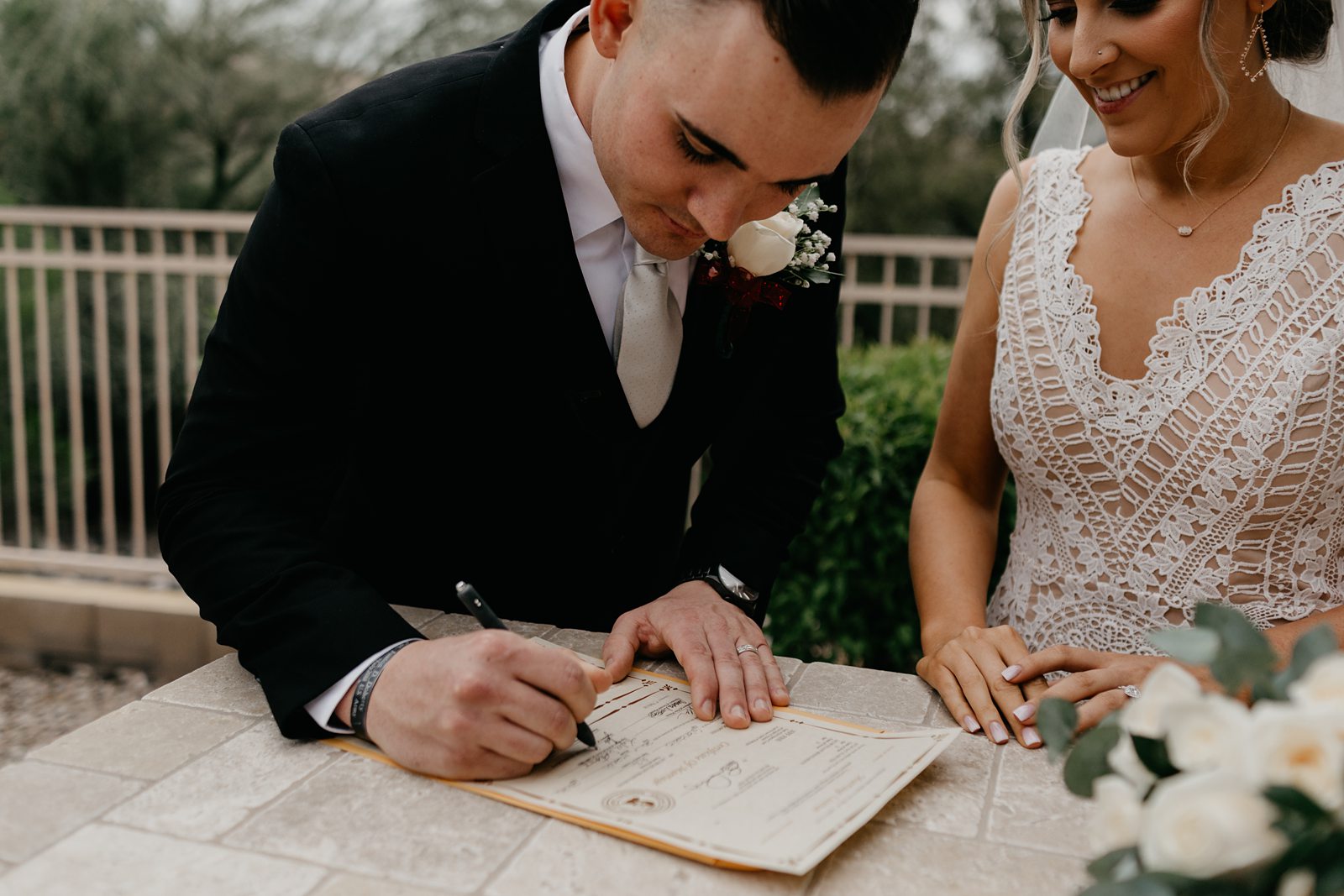 Groom casually signing his marriage license at his backyard wedding in Arizona