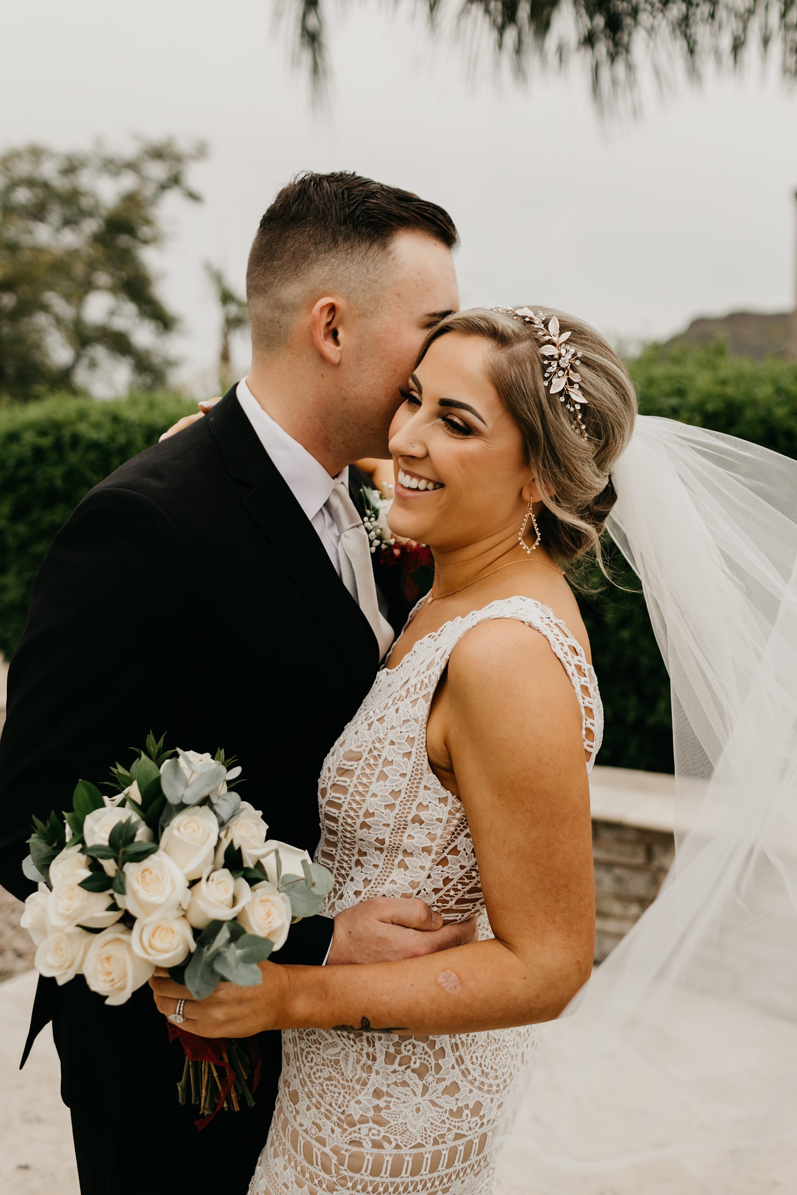 Fun portrait of bride and groom laughing at their intimate backyard elopement in Phoenix Arizona with her veil swishing