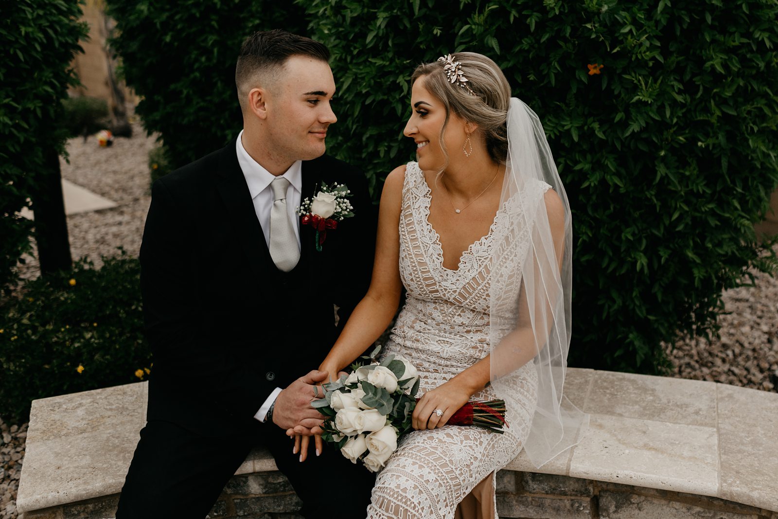 Wedding photo of bride and groom sitting looking at each other