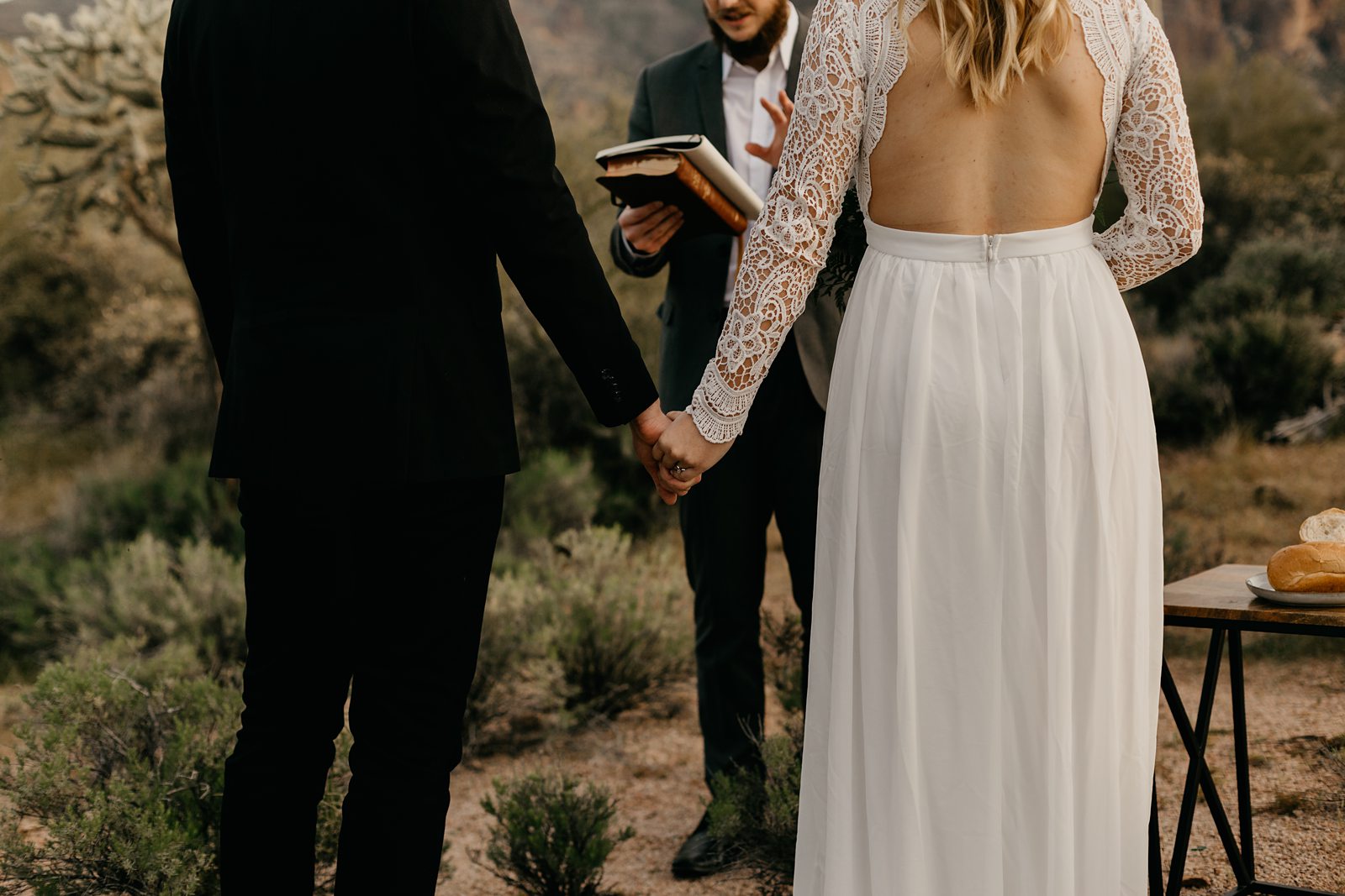 intimate wedding couple holding hands during the cermeony in the desert phoenix AZ