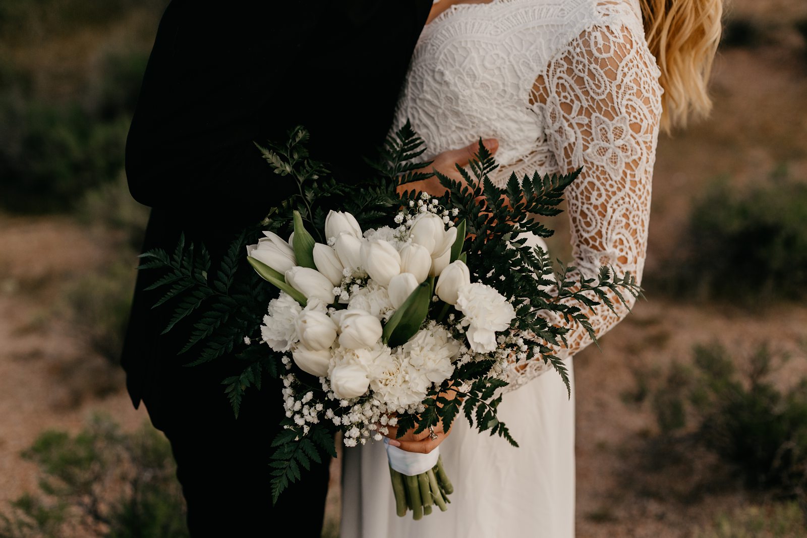 bride with boho lace dress and white tulip bouquet