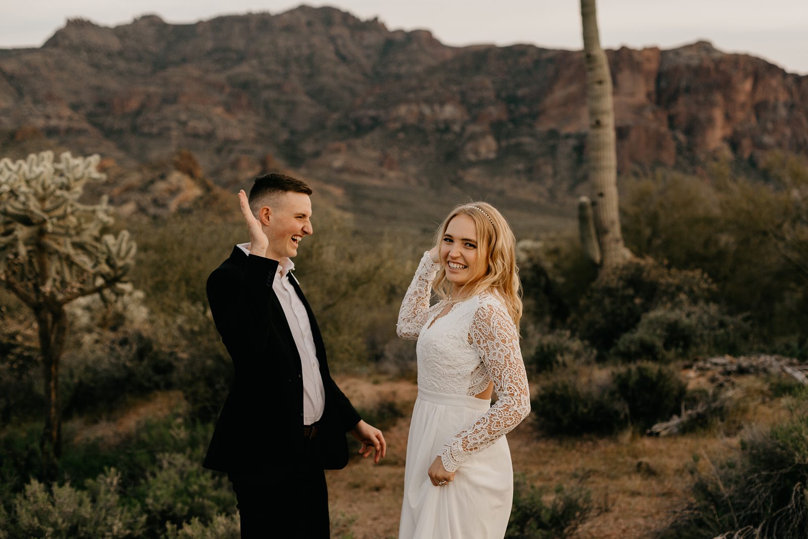 silly fun wedding picture of bride and groom high-fiving in the arizona desert