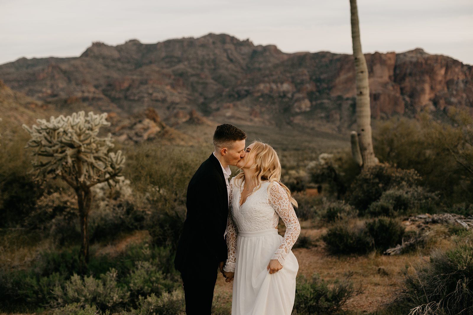 silly fun wedding picture of bride and groom high-fiving in the arizona desert