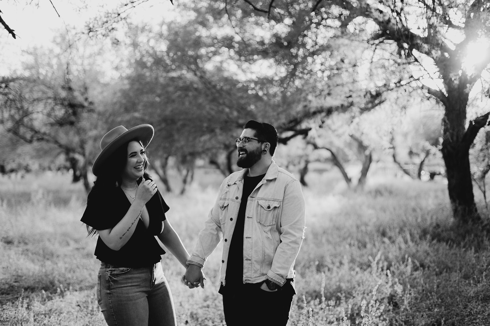 black and white picture of couple laughing Grass and trees in arizona coon bluff engagement session by the salt river in Mesa