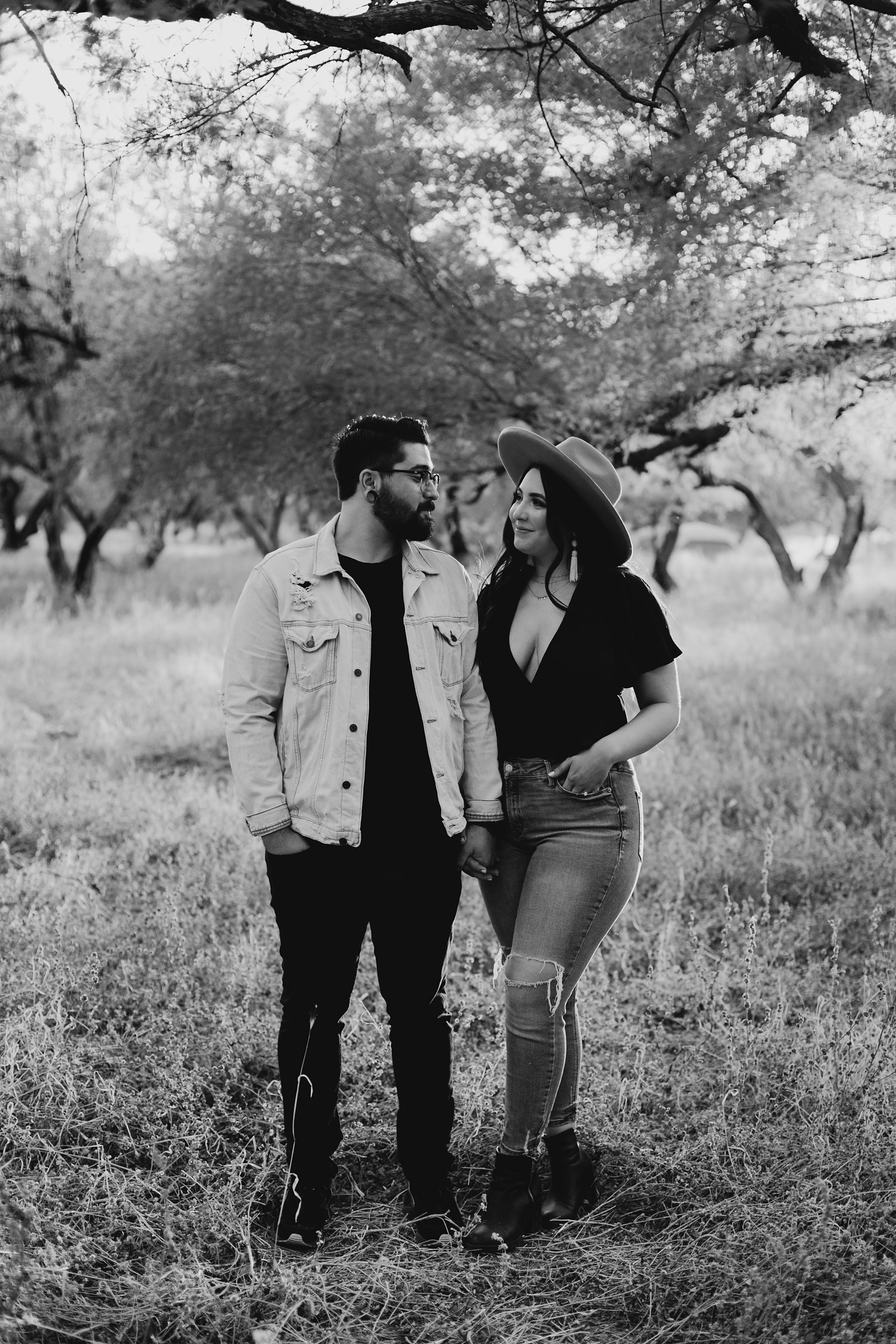 black and white young couple's engagement photos around grass and trees at coon bluff in phoenix arizona