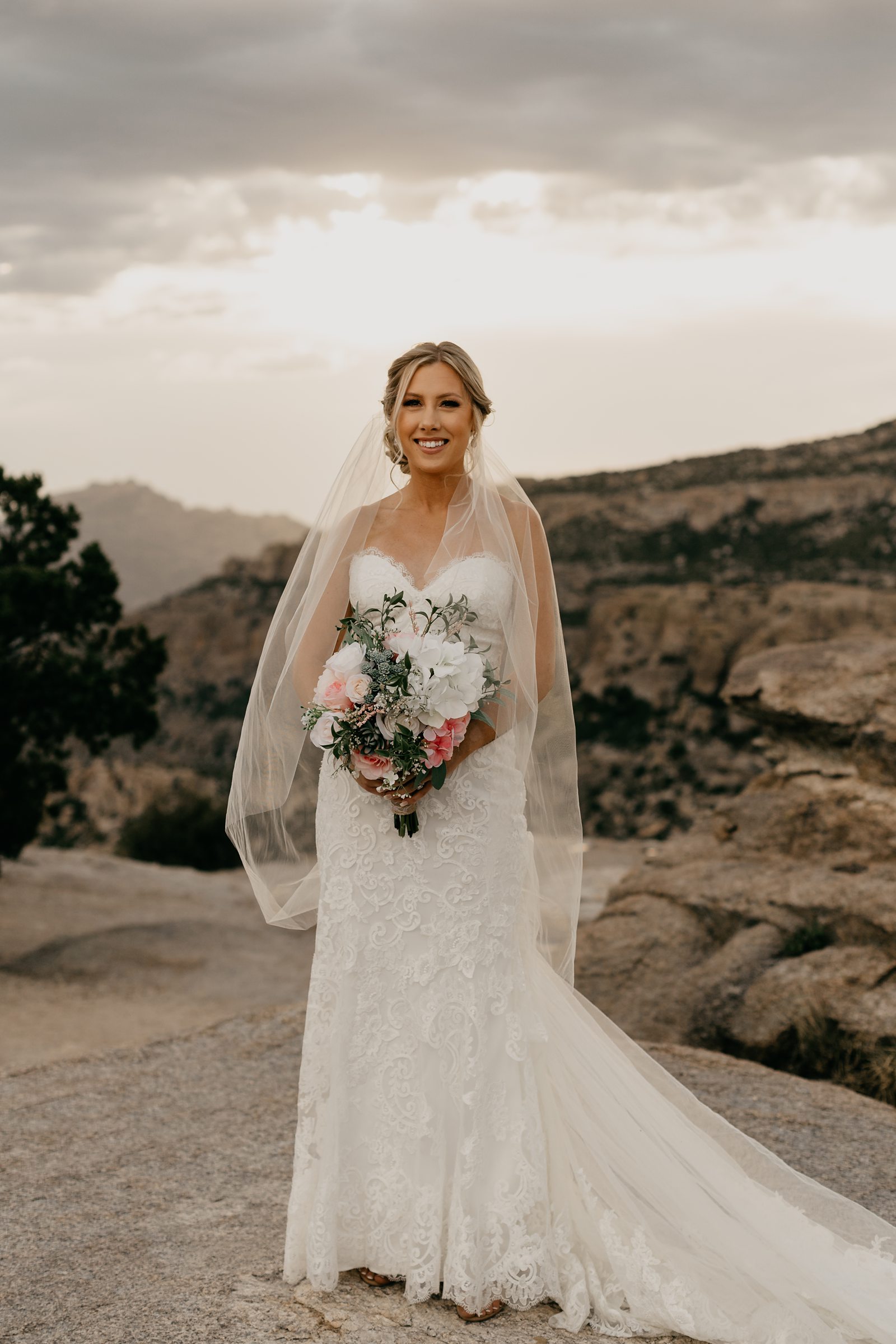 Portrait of bride with bouquet in Veil on top of mountain in Arizona