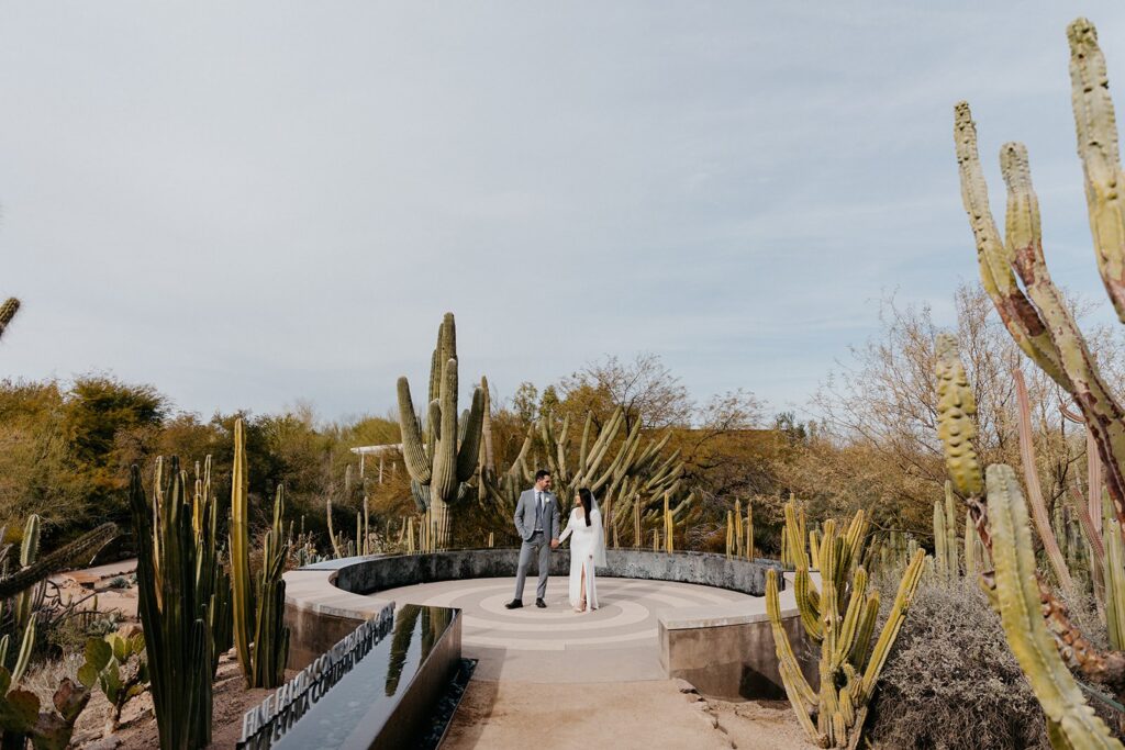 Couple standing side-by-side at the Desert Botancial Garden, surrounded by saguaro cactus