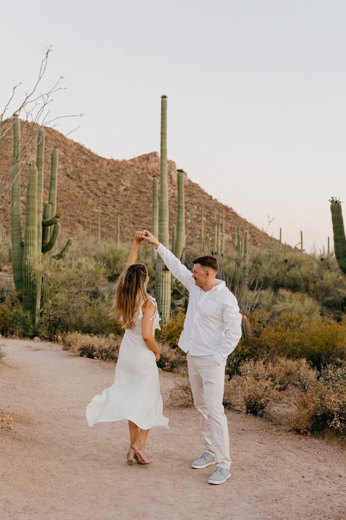 Couple in all white, twirling in the desert in Tucson AZ