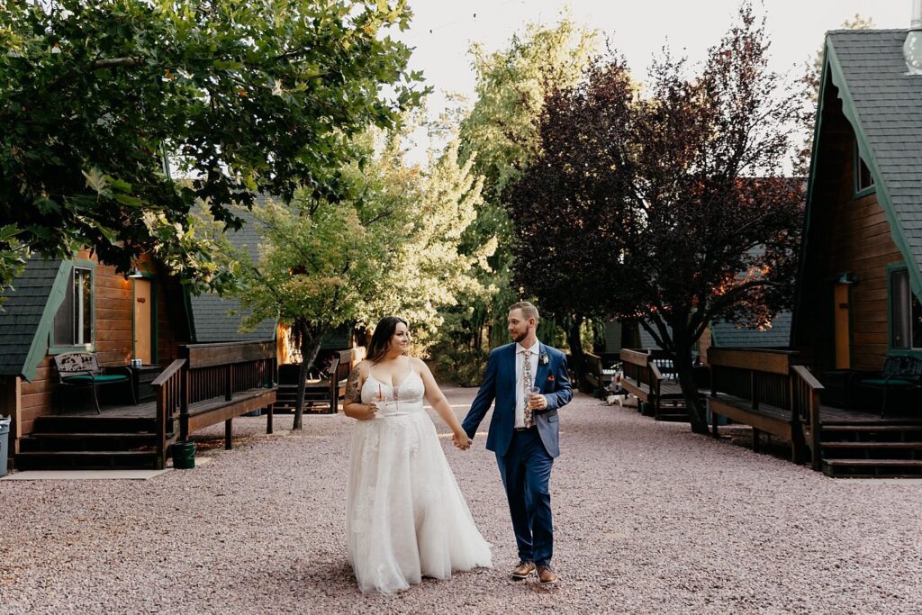 Wedding couple walking past a-frame cabins and fall folliage in Strawberry AZ